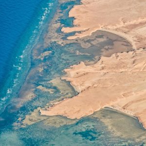 Vista aérea de la costa del Mar Rojo con aguas turquesa, arrecifes y formaciones desérticas cerca de Sharm El Sheikh en Egipto.