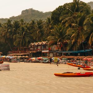 Playa tropical en Goa con palmeras, arena dorada y el Mar Arábigo al atardecer.