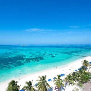 Vista aérea de Spratt Bight en San Andrés, Colombia, con el mar de los siete colores y playa de arena blanca.