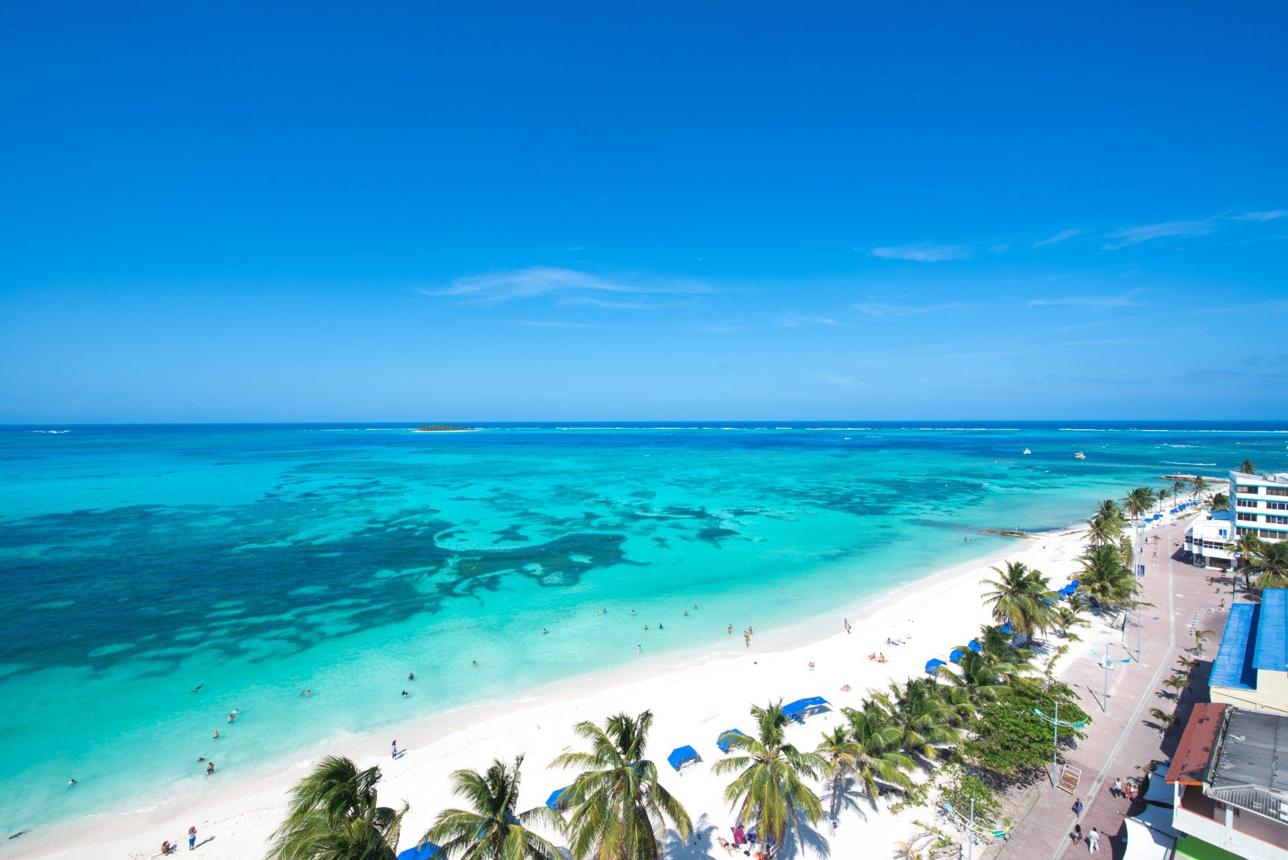 Vista aérea de Spratt Bight en San Andrés, Colombia, con el mar de los siete colores y playa de arena blanca.